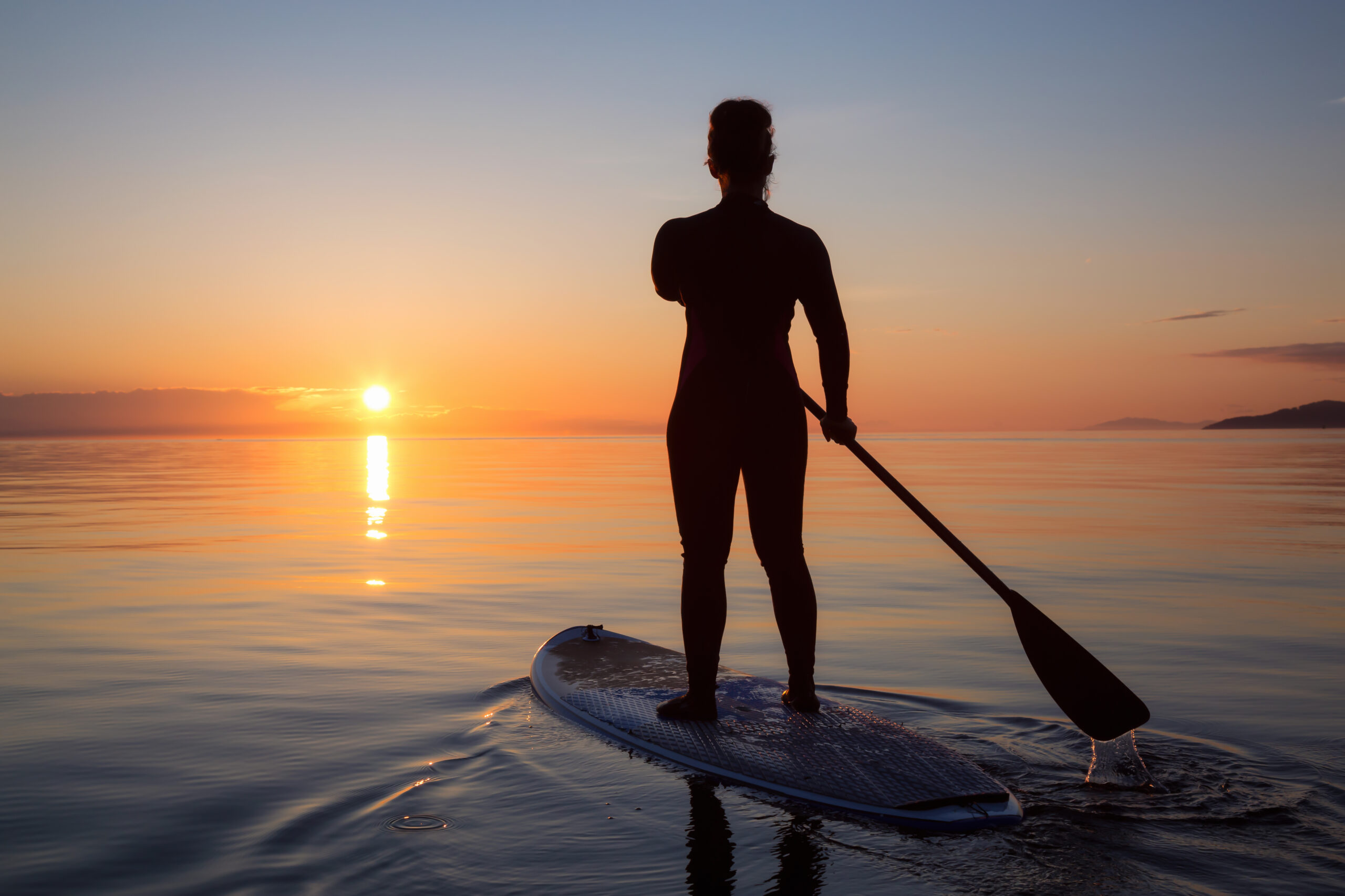 Persona practicando paddleboarding en la tranquila bahía de Altata