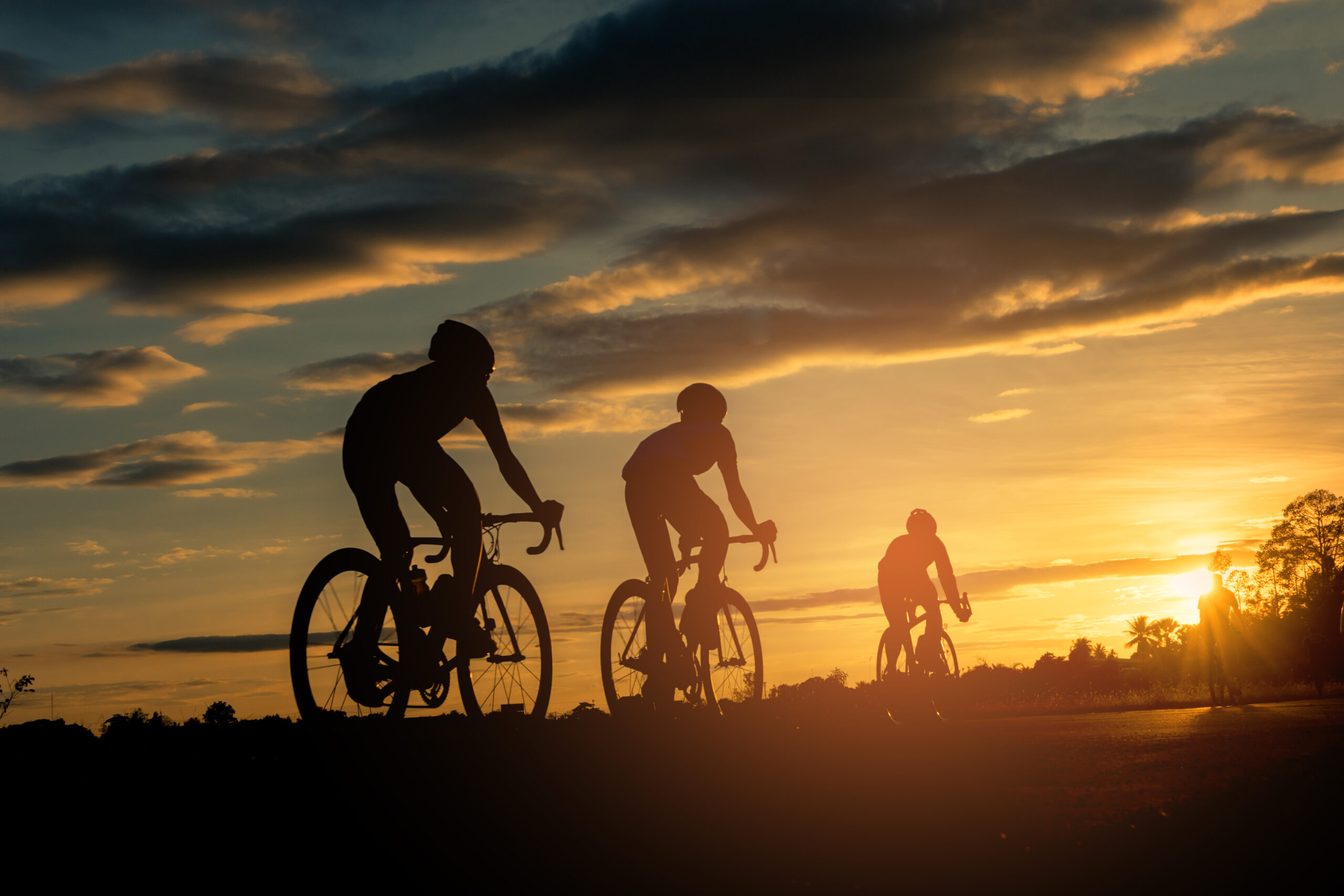 Ciclistas de montaña con el atardecer de fondo