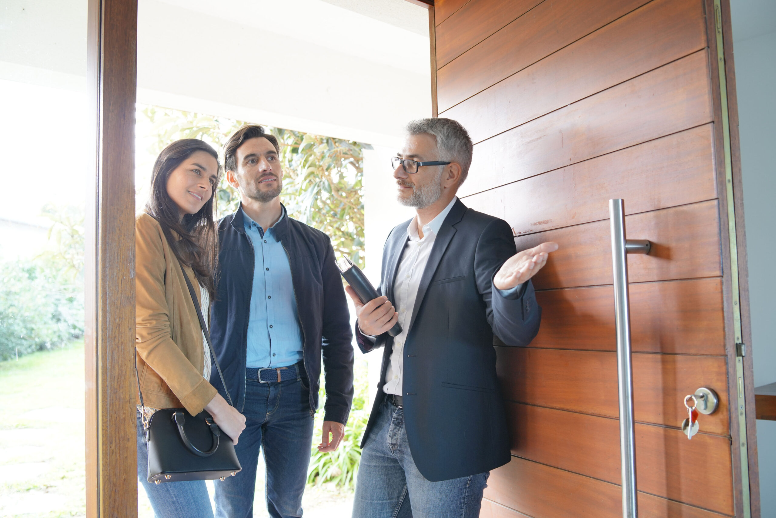 Couple with real-estate agent visiting modern house