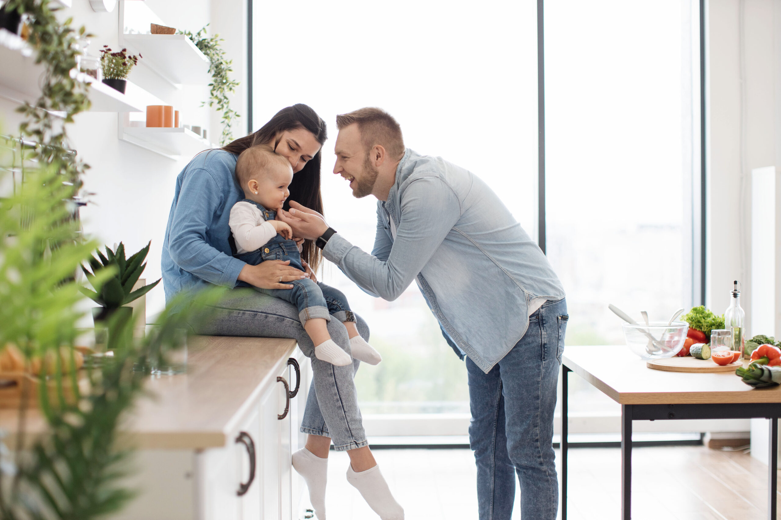 Mother with child sitting on countertop with dad in front