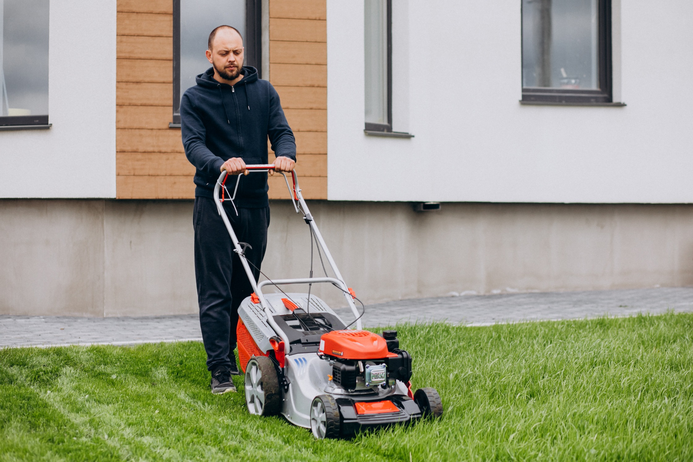 man-cutting-grass-with-lawn-mover-back-yard