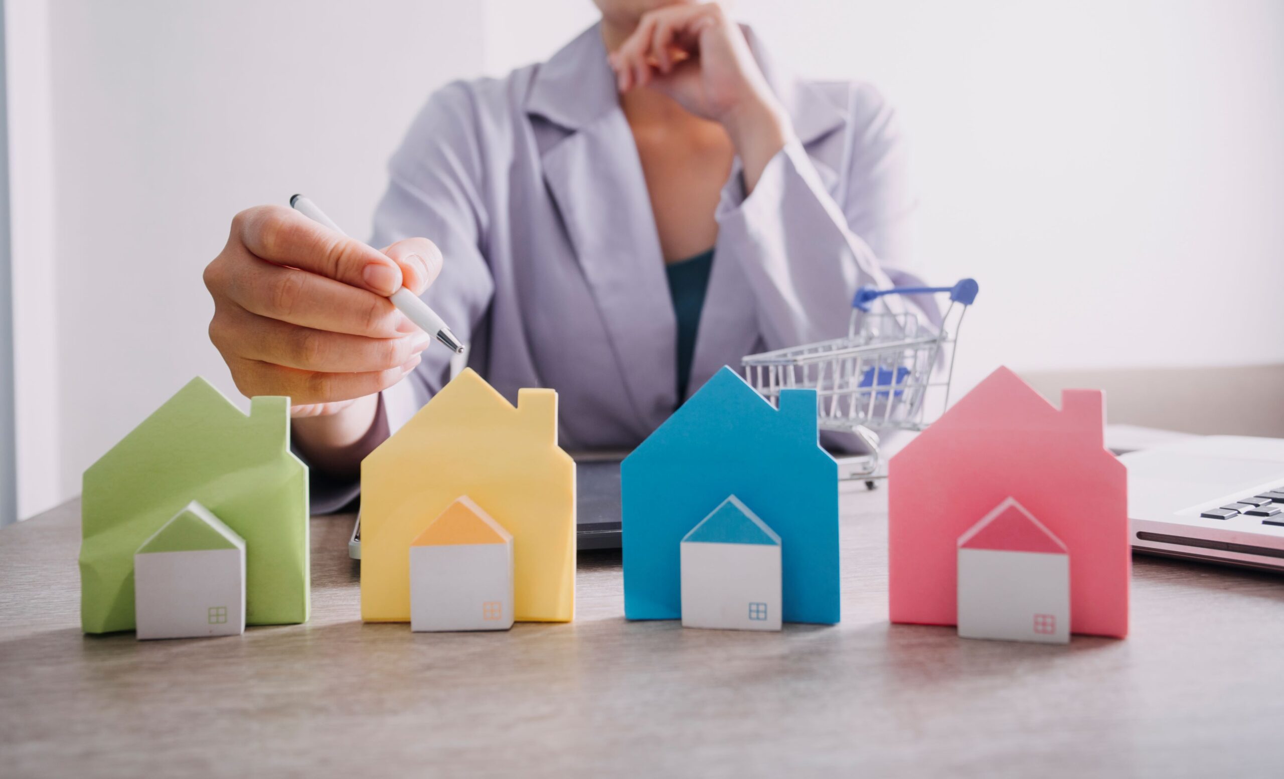 hand-is-pressing-calculators-piggy-bank-with-wooden-house-buy-rent-question-note-with-calculators-desk-save-money-buy-house-concept