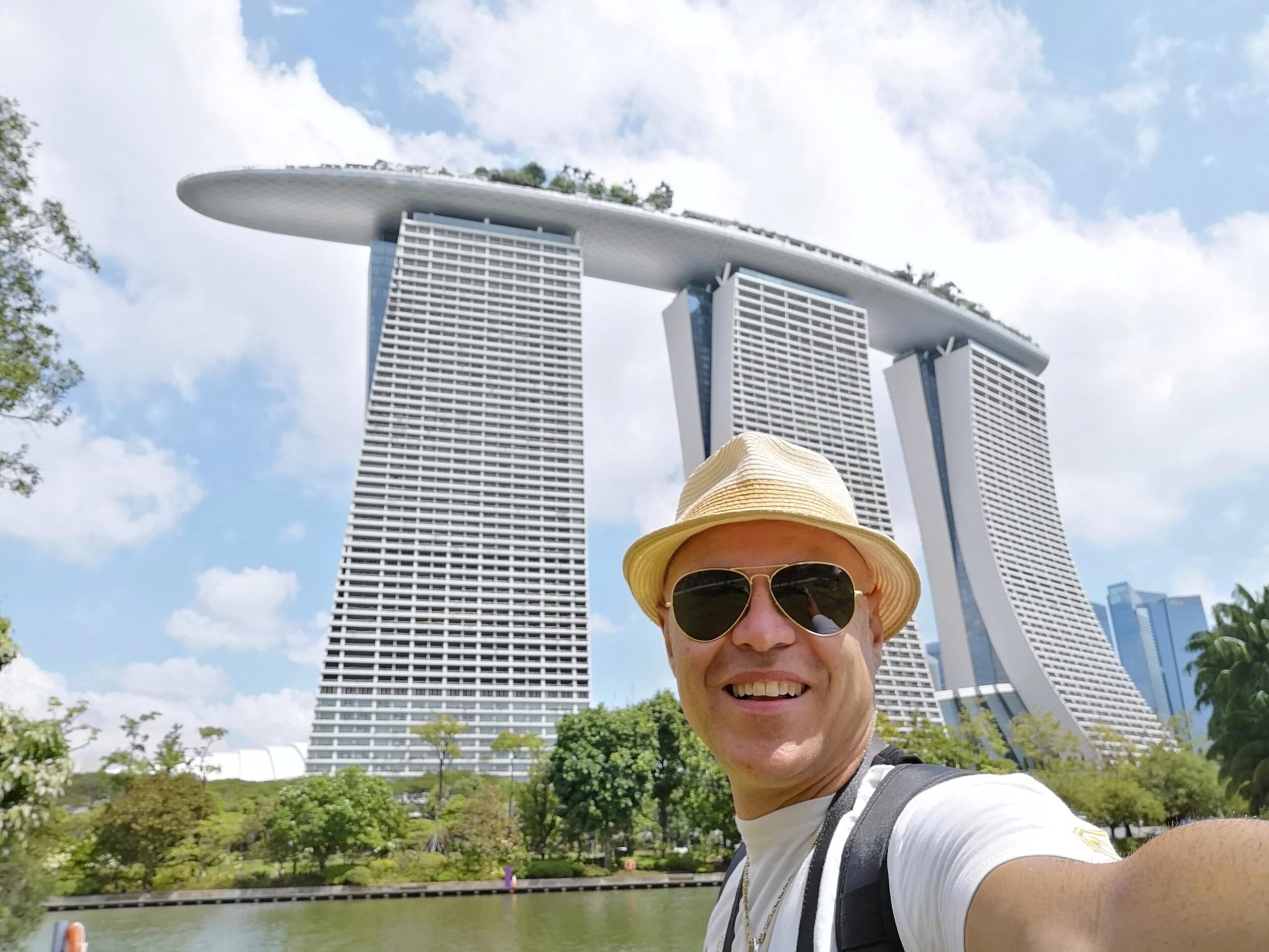 portrait-smiling-man-wearing-sunglasses-against-marina-bay-sands-sky