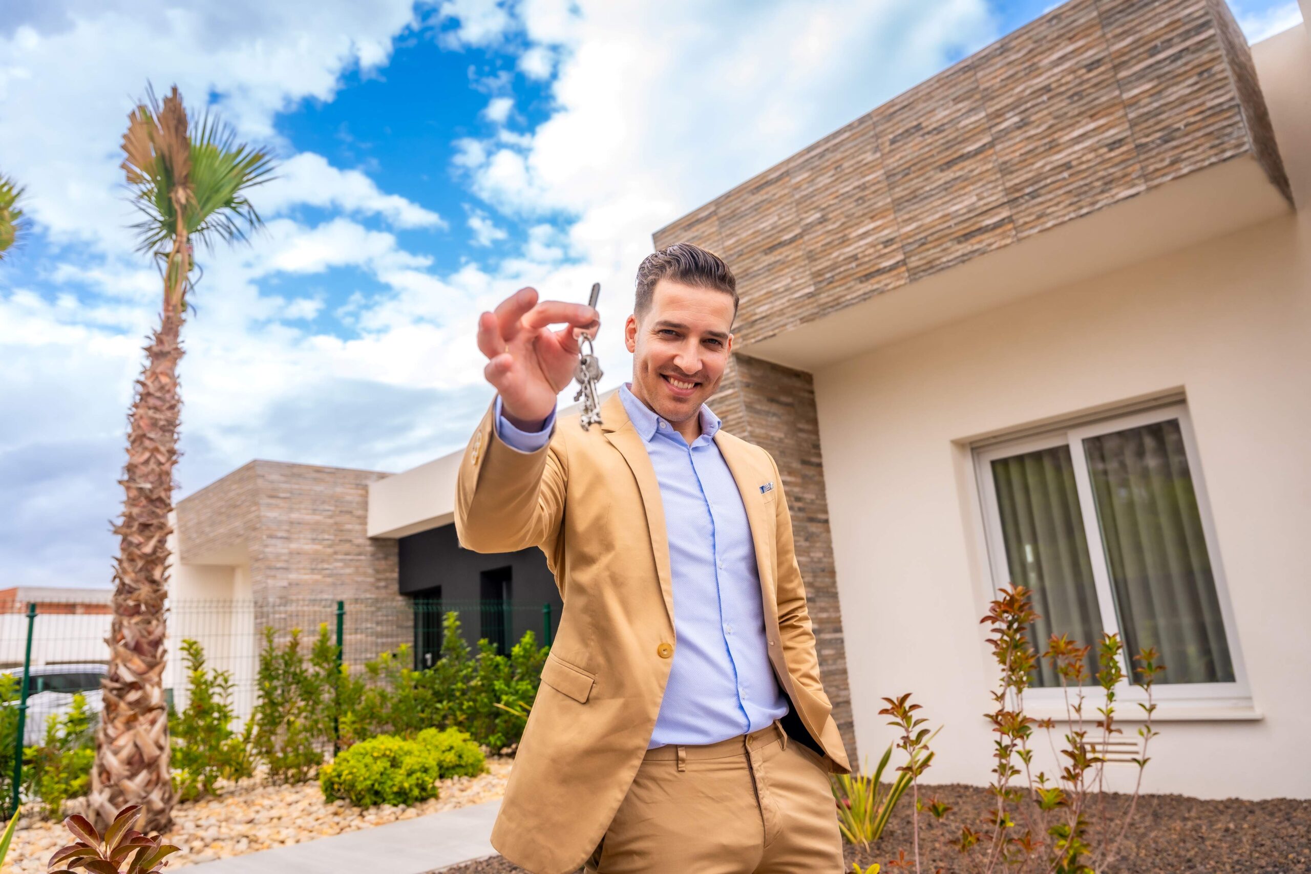 Joven ofreciendo las llaves de una casa en venta