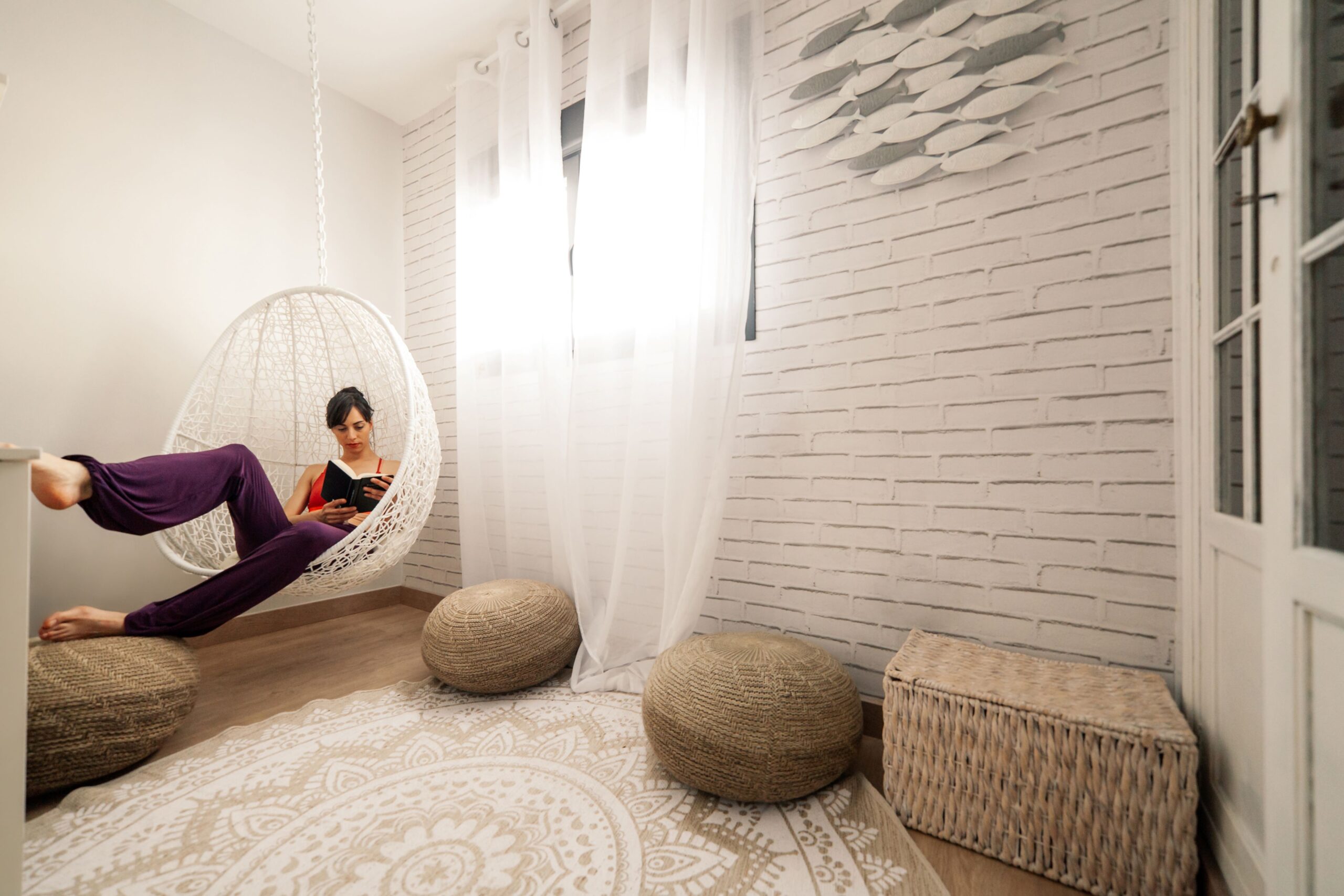 Joven Mujer Leyendo Libro en Sala con Decoración Estilo Japandi