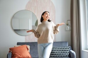 Joven mujer reflejando sus emociones y energi positiva en el interior de su hogar