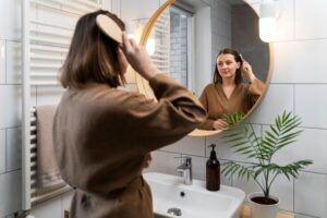 Mujer reflejandose en un Espejo de un tamaño moderado de manera de equilibra la energia