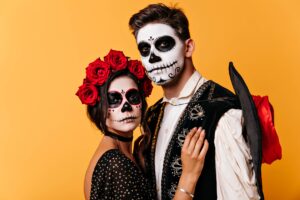 pareja de jovenes pintados del rostro con imagen de calaveras