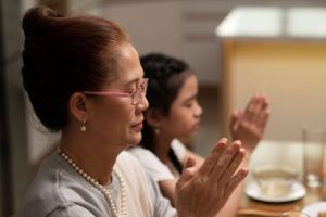 Familia dando las gracias a Dios y santificando los alimentos parte de un hogar sagrado