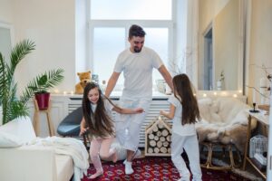 Hijas jugando con papá al interior de su hogar sagrado