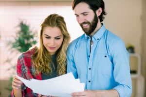 Cerrando el trato de la compra de la casa, pareja revisando documentos