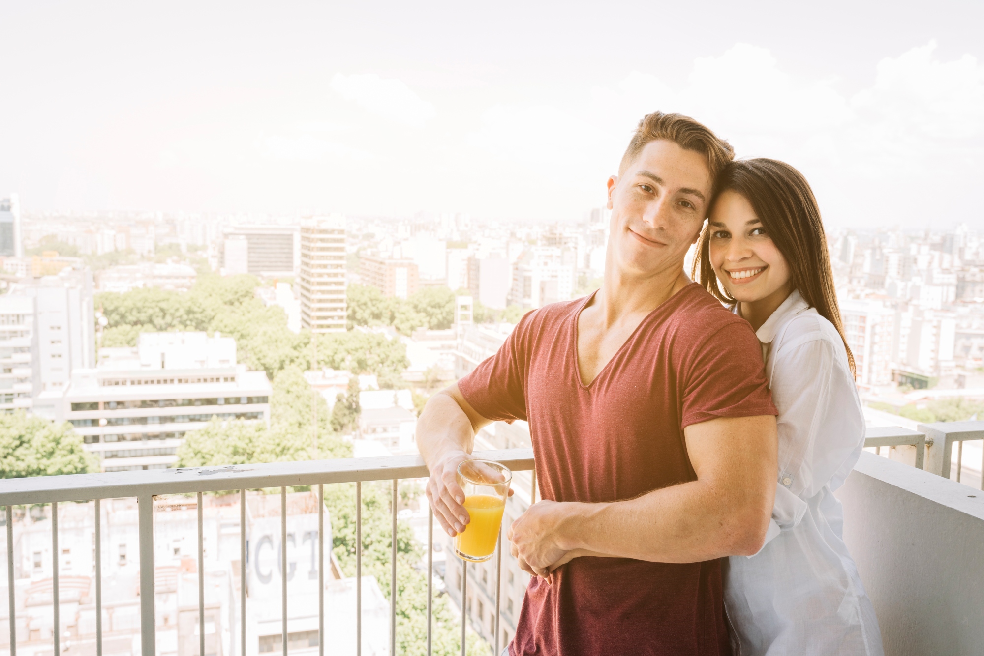 Pareja feliz en el balcon de su departamento