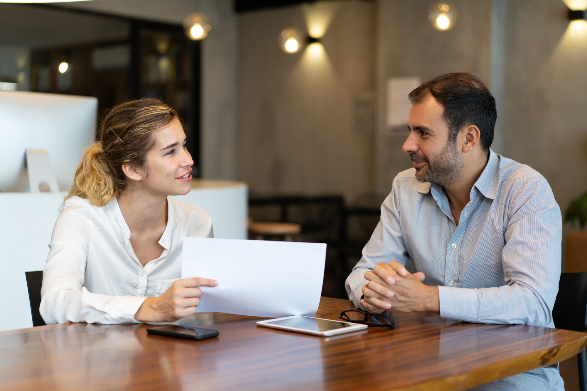 Matrimonio joven revisando documentación y contrato de compraventa de una propiedad
