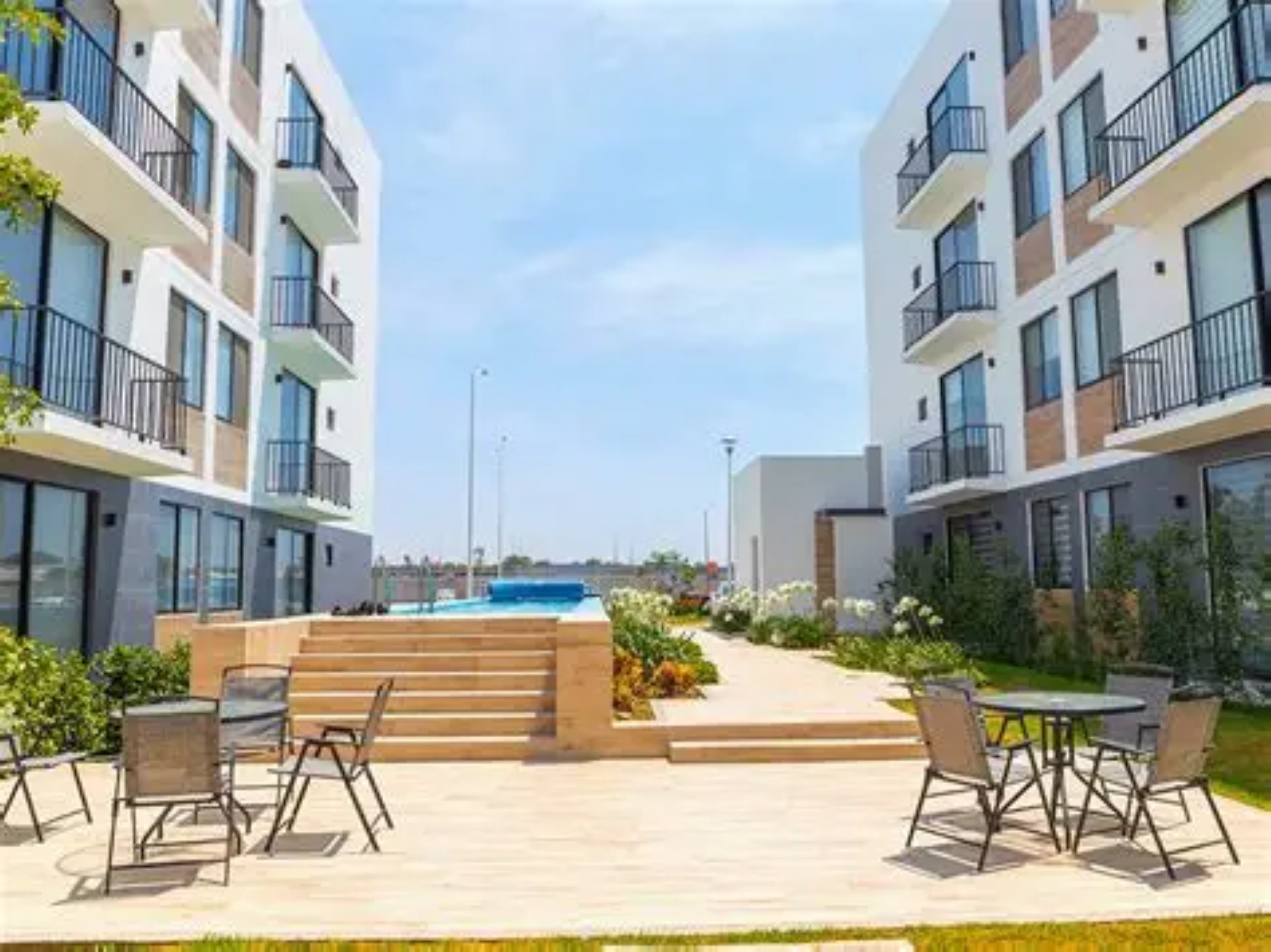 Espacio recreativo en Capittala León, son dos torrres de departamentos a los costados y al centro una alberca de un solo carril y dos juegos de mesas con cuatro sillas