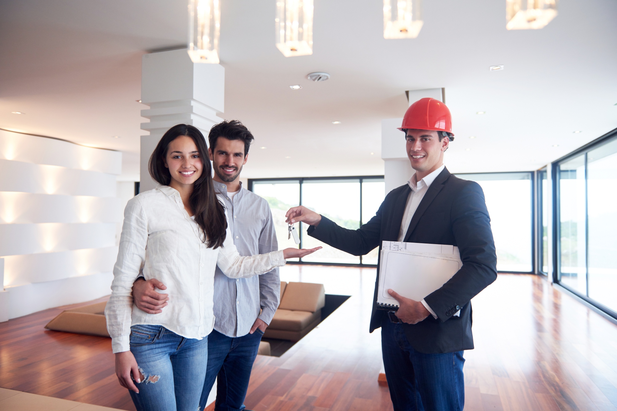 Familia joven feliz, pareja que compra una casa nueva con agente inmobiliario
