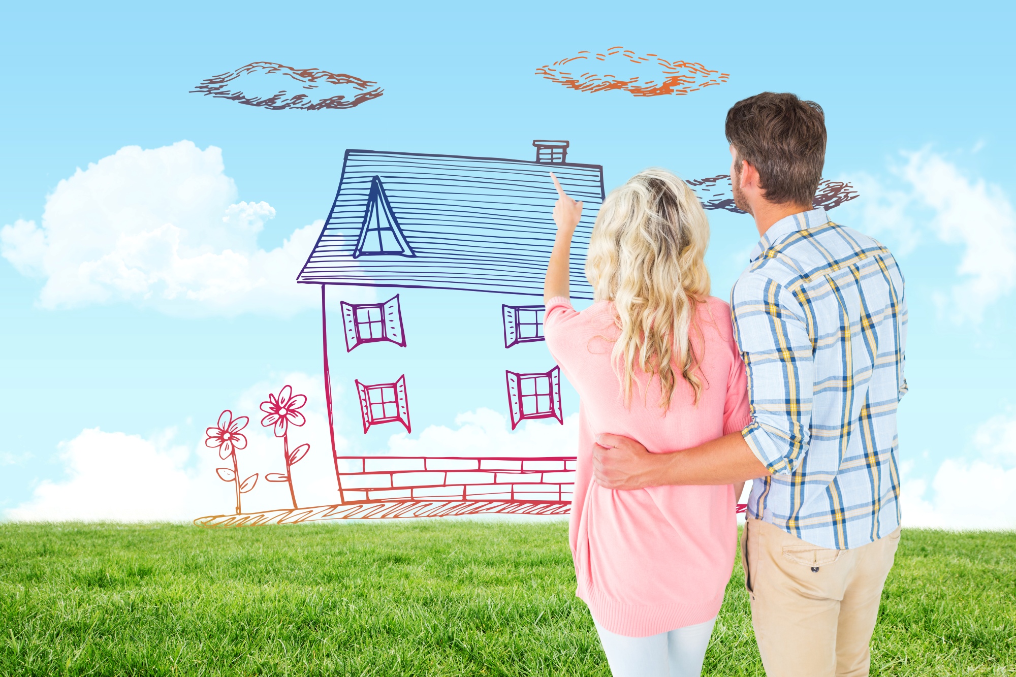 Pareja atractiva de pie y mirando el terreno donde estan trazando en su imaginación su casa sobre el campo verde