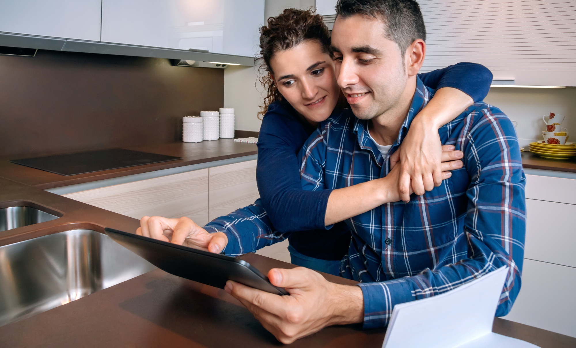 Pareja sonriente buscando en línea en Inmobiliaria Indigital la casa o departamento dónde van a vivir