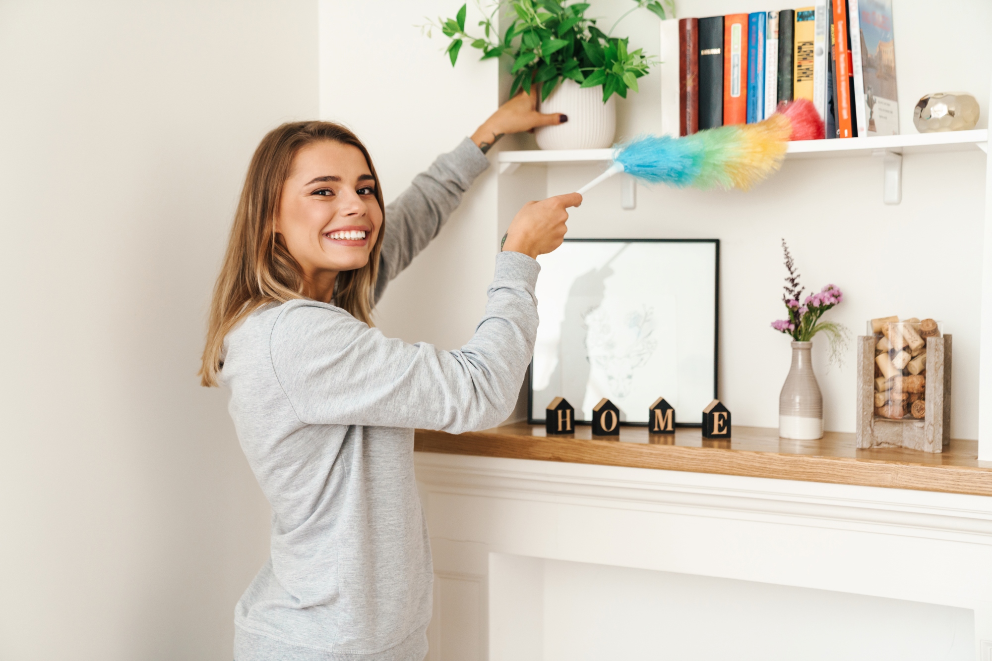 Alegre joven hermosa ama de casa sonriendo organizando decorando y realizando las tareas del hogar
