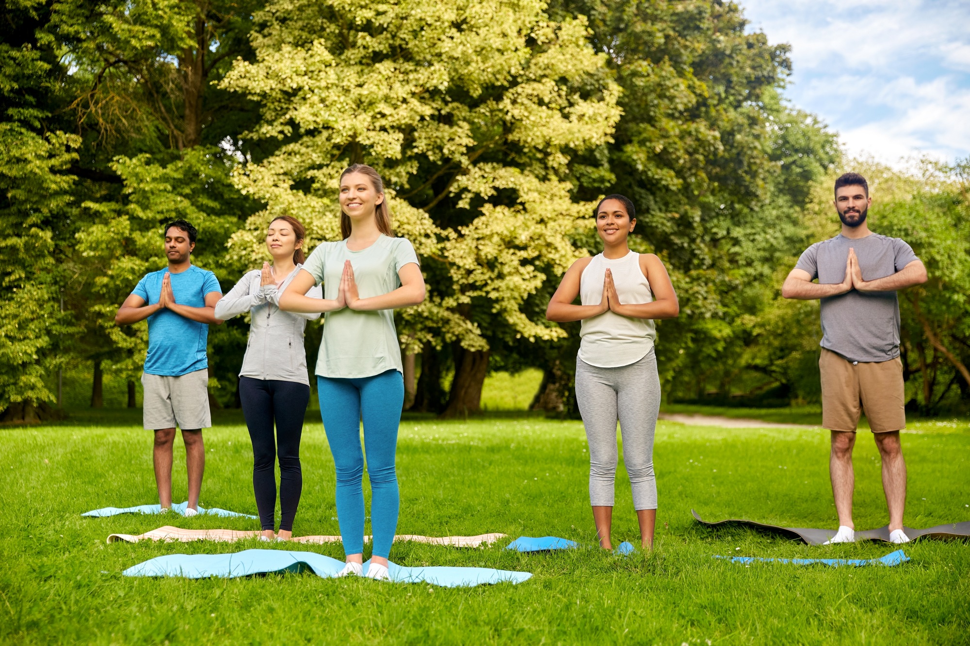 Grupo de personas haciendo yoga en las áreas verdes del desarrollo inmobiliario Comunidad y Calidad de Vida