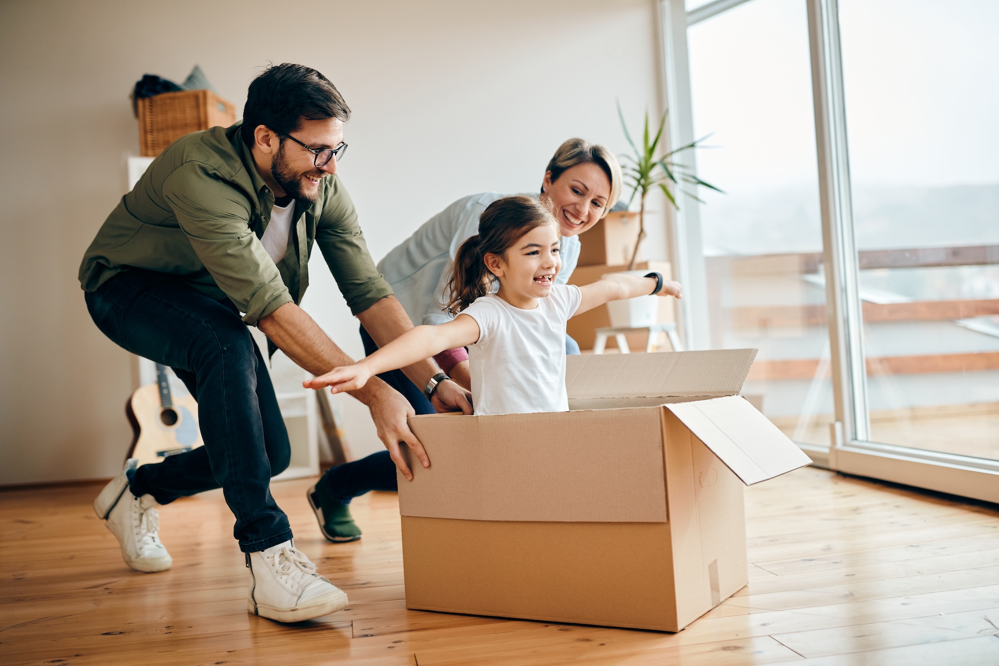 hija-feliz-divirtiendose-con-sus-padres-mientras-se-muda-un-apartamento-nuevo.
